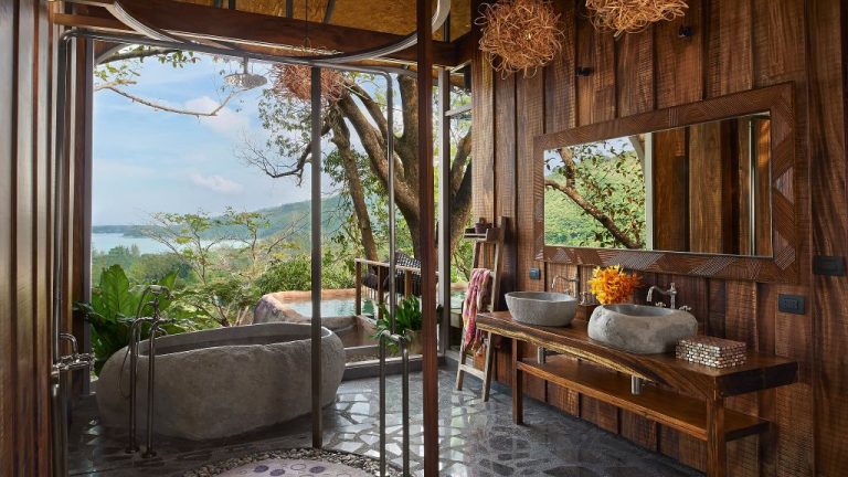beautiful open air bathroom with stone bathtub and view
