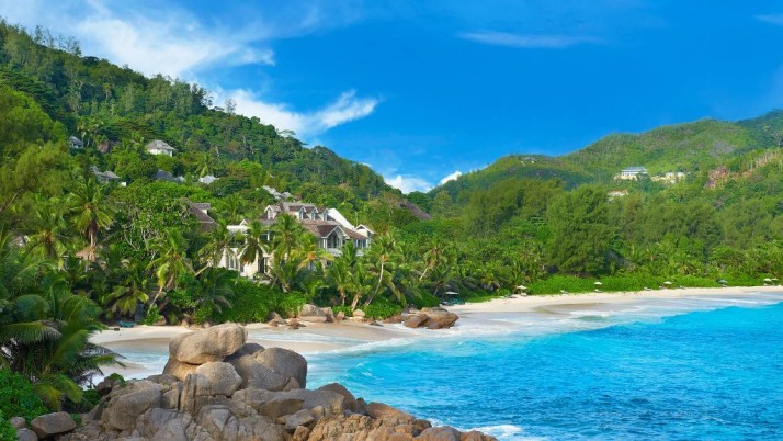 Banyan Tree Seychelles view of white sandy beach and turquoise water with hotel beyond