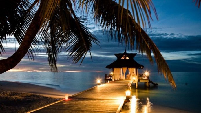 Banyan Tree Maldives Vabbinfaru dock and palm tree at sunset