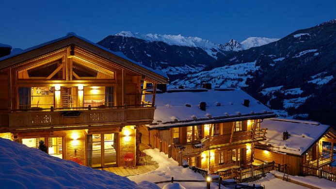 lodge at nightfall with snow-covered mountains