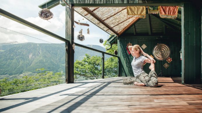 female yoga on terrace with mountain view