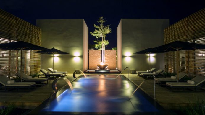 pool with lounge chairs at nighttime