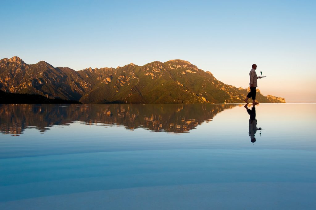 Man on the edge of Belmond Hotel Caruso's infinity pool