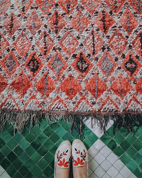 Teal and red rug with matching embroidered shoes
