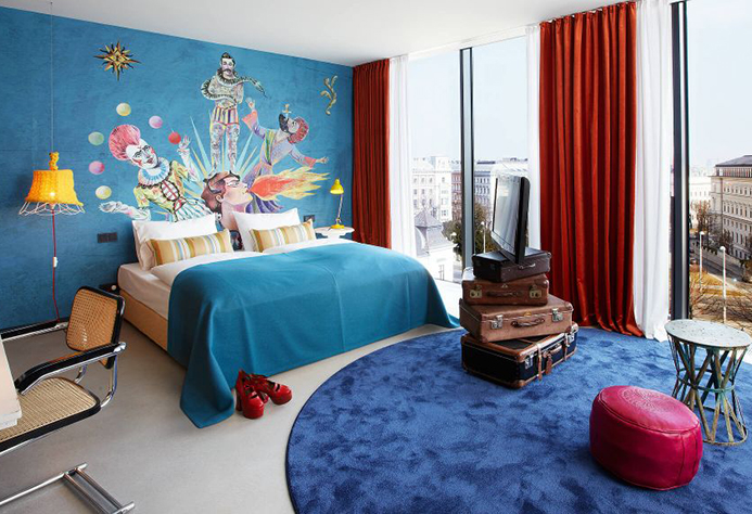 25hours Hotel Wien suite with clown mural and vintage luggage set