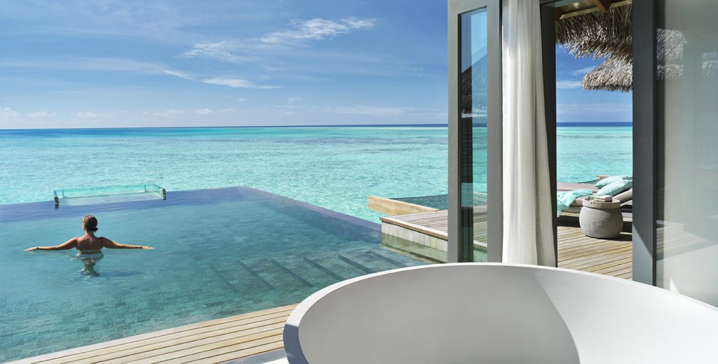 Vakkaru Maldives overwater villa with woman in private pool