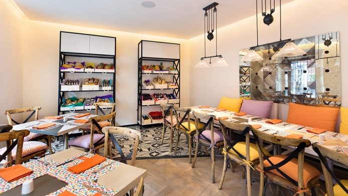 Hotel Cartesiano's Café Hercilia interior with tables and market shelves