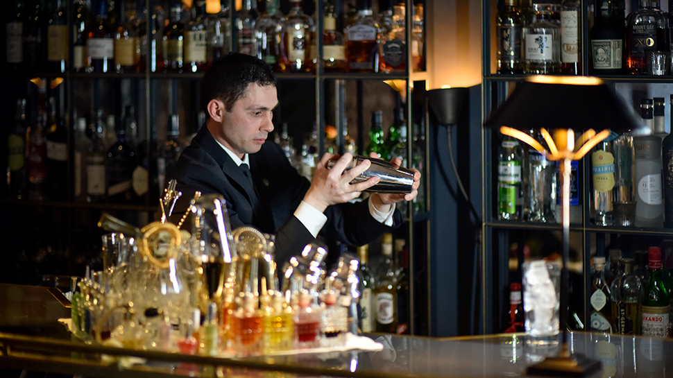 Mixologist Salvatore Maggio mixxing a cocktail behind The Franklin Bar