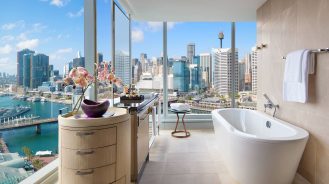 Corner bathroom with floor-to-ceiling views of the city at Sofitel Sydney Darling Harbour