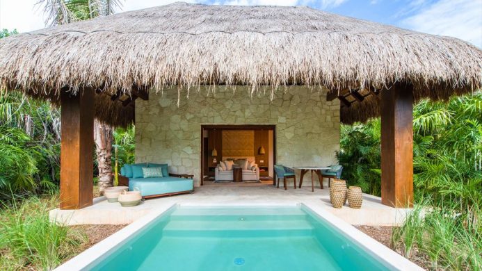 Private pool in front of thatched roof villa