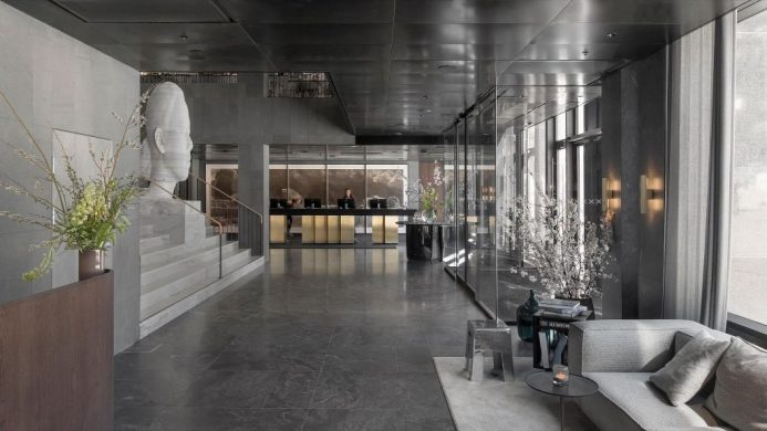 Spacious lobby with cement, marble and sculpture art