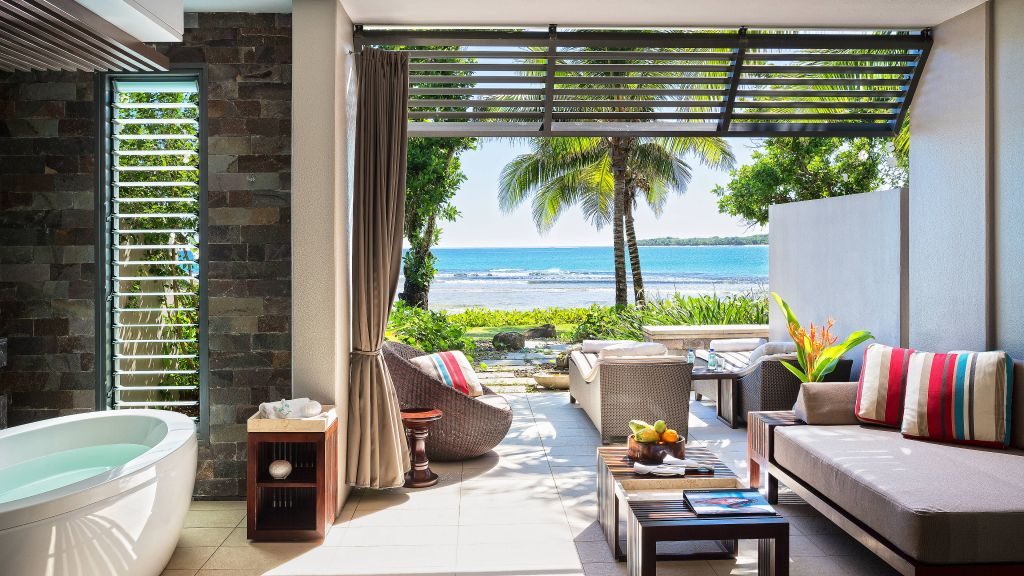 Villa with living room and bathtub opening to the beach and ocean