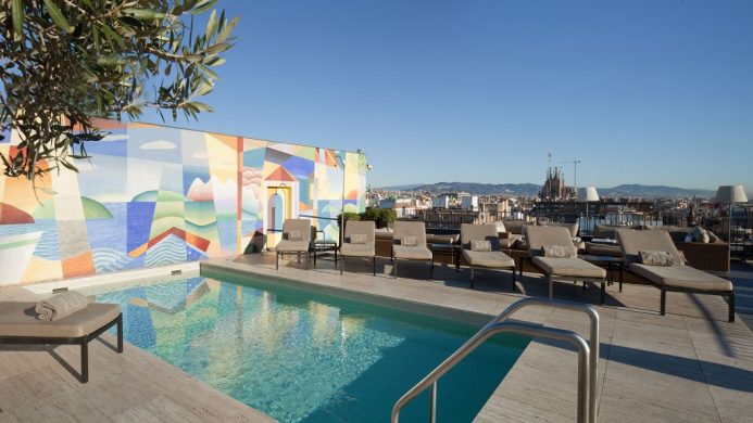 Sunny rooftop pool overlooking the spires of the Sagrada Familia