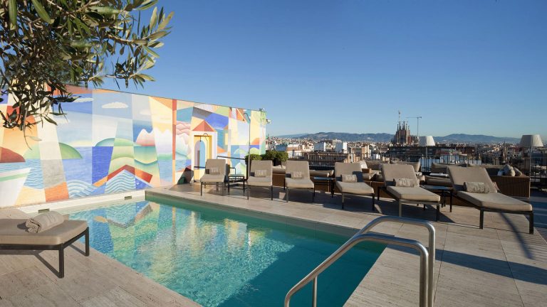 Sunny rooftop pool overlooking the spires of the Sagrada Familia