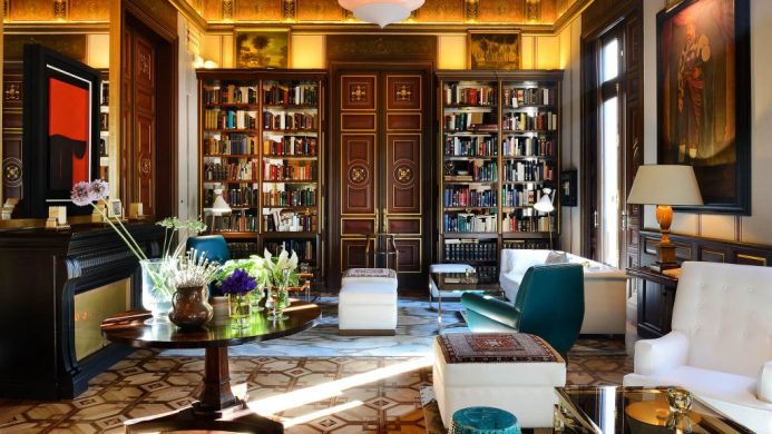 Small library with sofas, wood panelled door and oil paintings