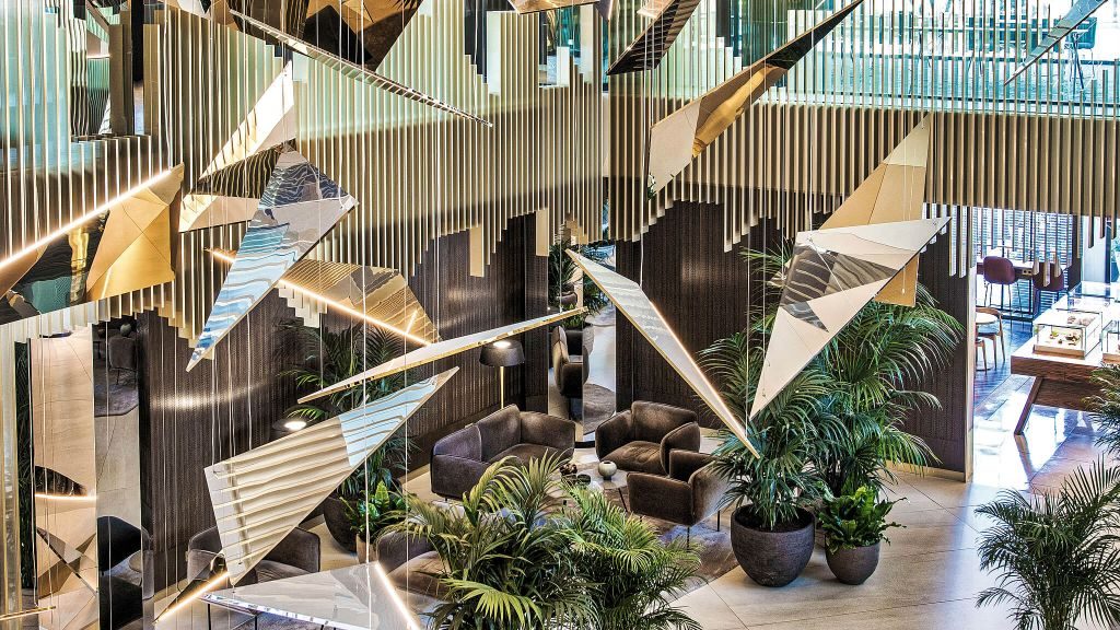 Modern lobby with high ceilings, geometric shapes and large potted plants