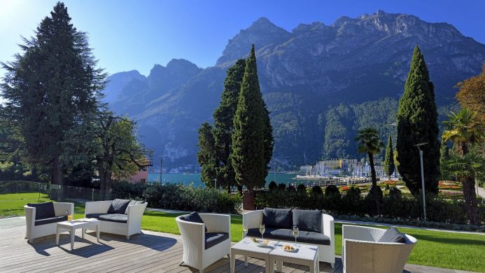 Lido Palace's open patio seating overlooking lake and mountain peaks