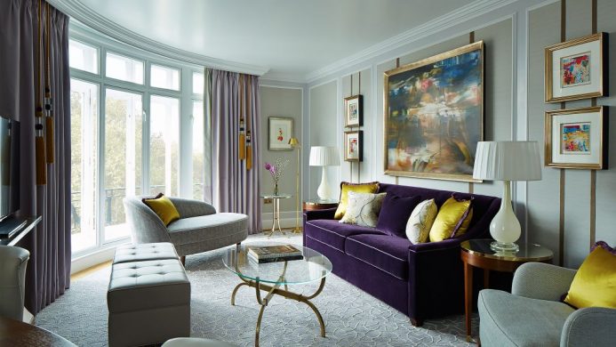 Suite living room at the London Marriott Hotel Park Lane with purple sofa and curved balcony