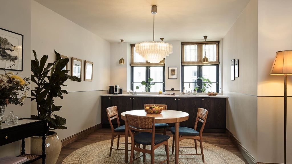 Hotel Sanders' suite kitchenette with small vintage dining table and large potted plant