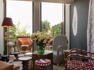 Guest room sitting area with retro chairs and window at the Brach Paris