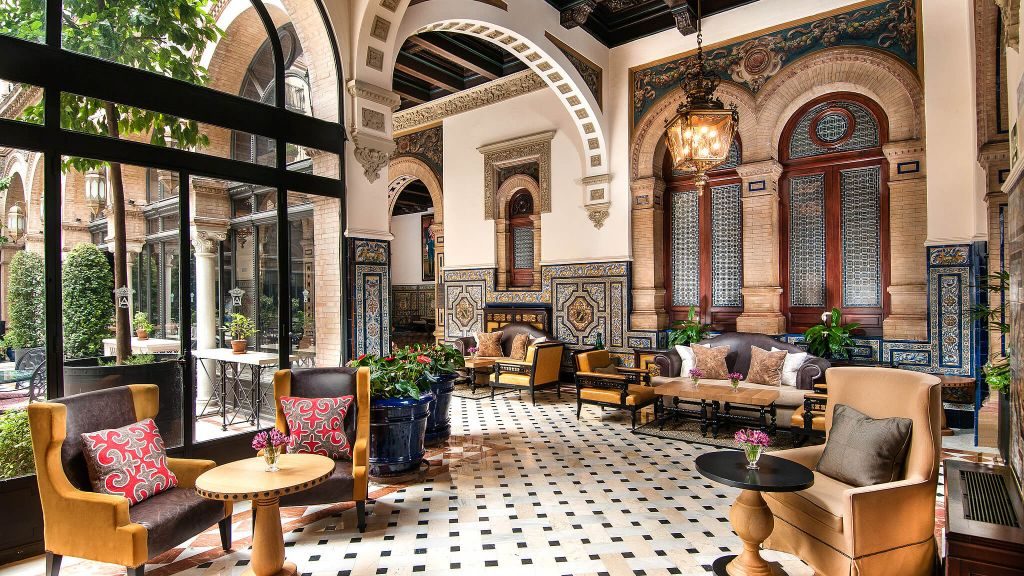 Hotel Alfonso XIII glass-enclosed sitting area with Arabic architecture, looking out to garden