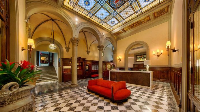 NH Collection Firenze hotel reception with arched columns and stained glass ceiling