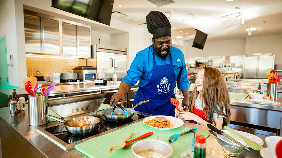 Chef teaching child in the SLS Baha Mar hotel kitchen