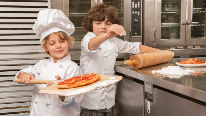 Kids making pizza in chefs whites at The Peninsula Beverly Hills