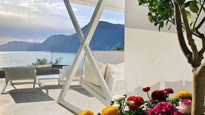 Casa Angelina deck with swing chair overlooking sea and mountain