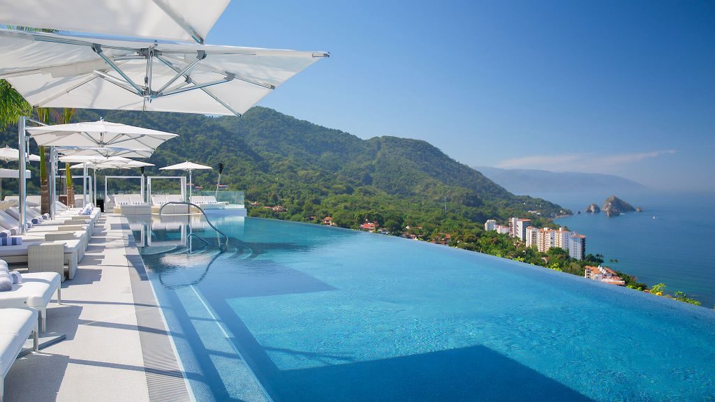 Hotel Mousai rooftop infinity pool towering over forested mountains and the ocean