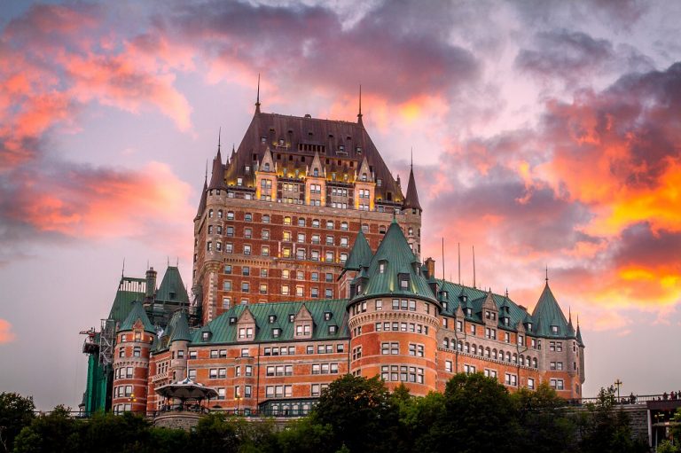 Exterior of Fairmont Le Chateau Frontenac in front of a fiery sky