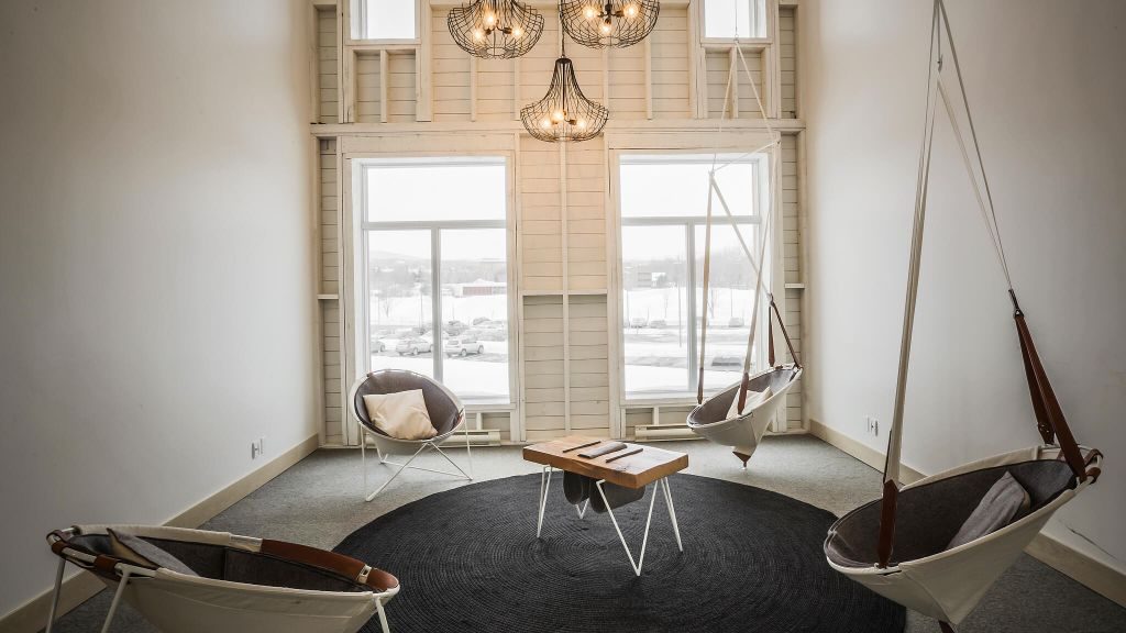 White lounge room with swing chairs at Le Germain Charlevoix Hotel