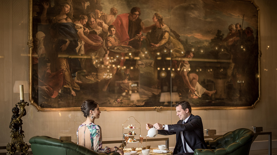 Couple having tea in front of oil painting at Rome Cavalieri hotel