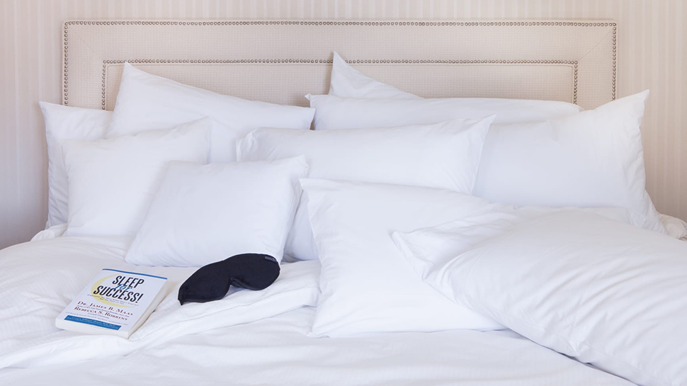 Sleep mask and sleep guide on white bed