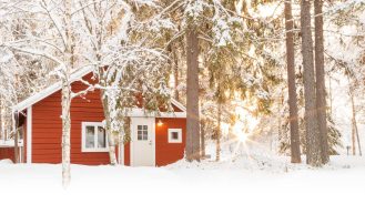 Loggers Lodge's red cabin in the forest covered in snow