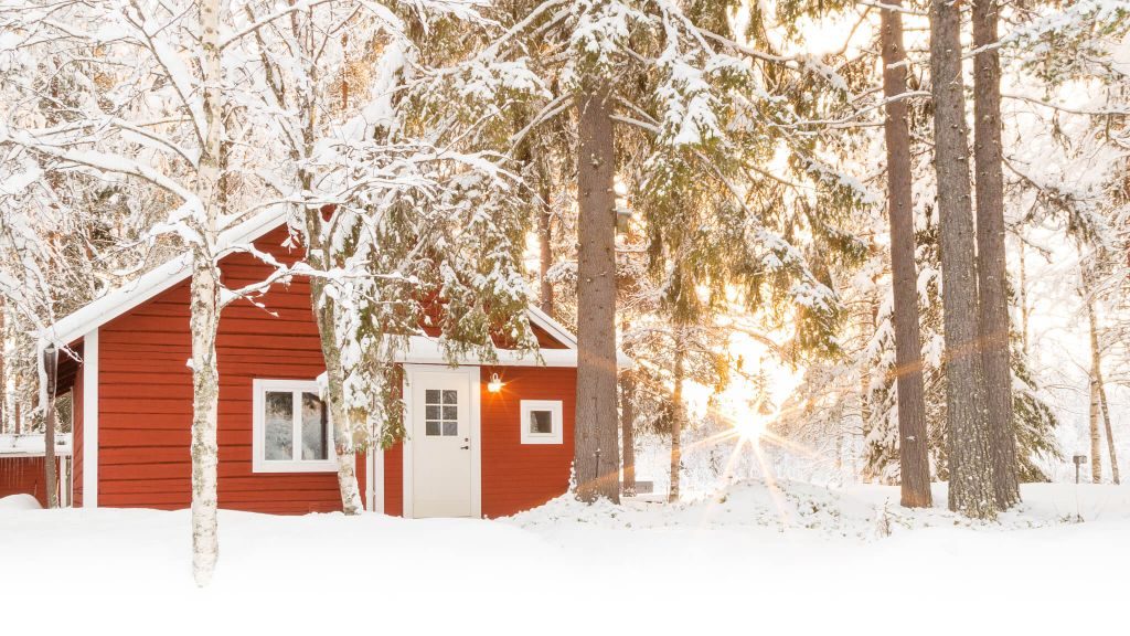 Loggers Lodge's red cabin in the woods covered in snow