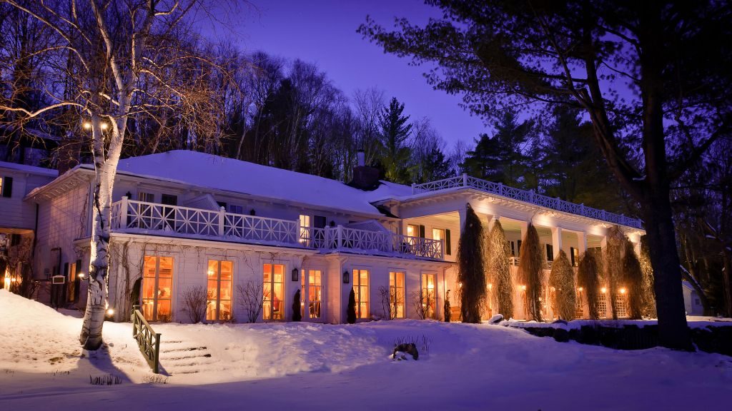 Exterior of Manoir Hovey at night in the snow