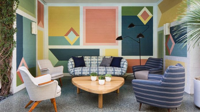 Avalon Hotel Beverly Hills outdoor seating with mid-century furniture against a colorful wall