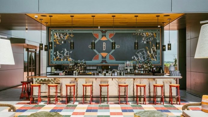 Bobby Hotel's bar counter with an Art Deco-style backsplash and rainbow floor tiles