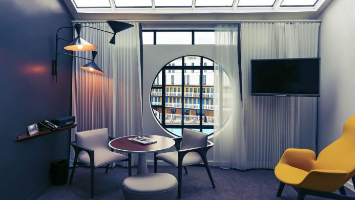 Hôtel Molitor Paris' room with a circular window looking out towards the courtyard pool