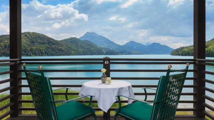 Schloss Fuschl's cottage balcony overlooking a lake and green hills