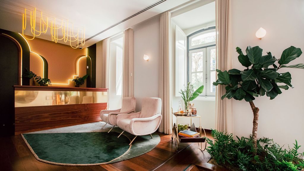 The Vintage Lisbon's lobby with a bar cart and potted plant