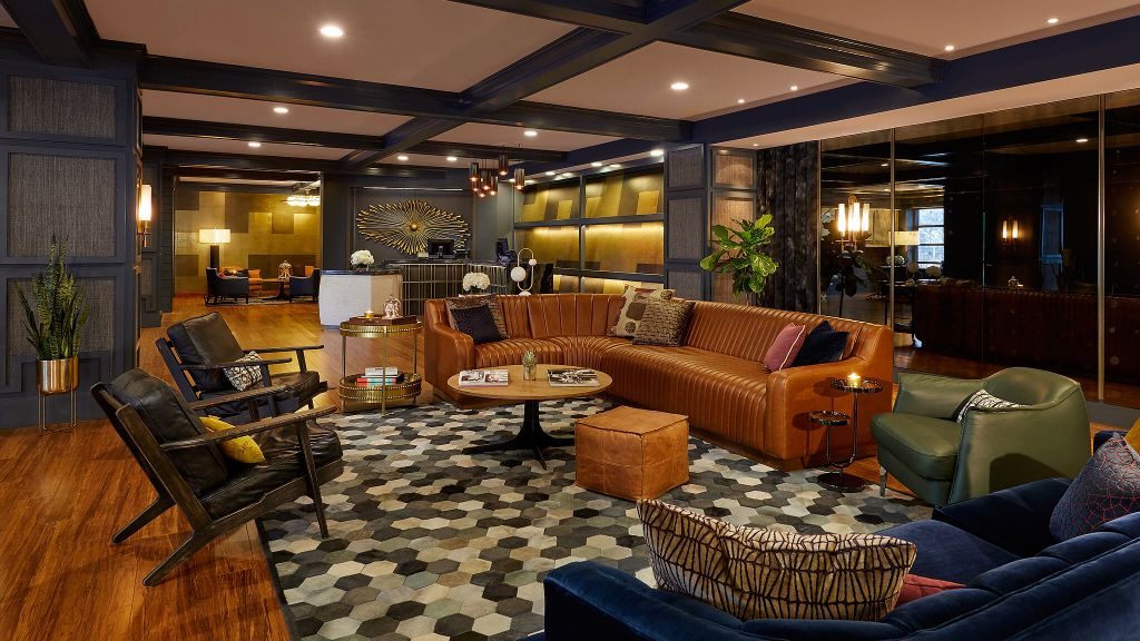 Hutton Hotel's lobby with wooden walls and a large leather sectional couch
