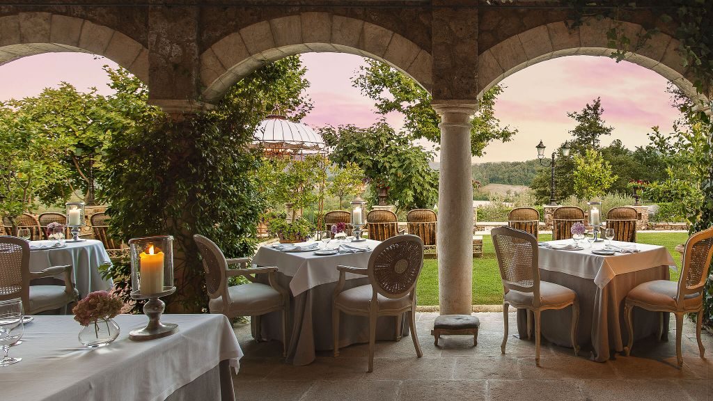 Borgo Santo Pietro Meo Modo Restaurant framed by arches overlooking a garden