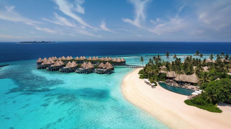 Remarkable Stays Near UNESCO World Heritage Sites | Nautilus Maldives | a beach with huts and a body of water