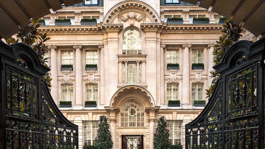 Exterior of Rosewood London behind open wrought iron gates