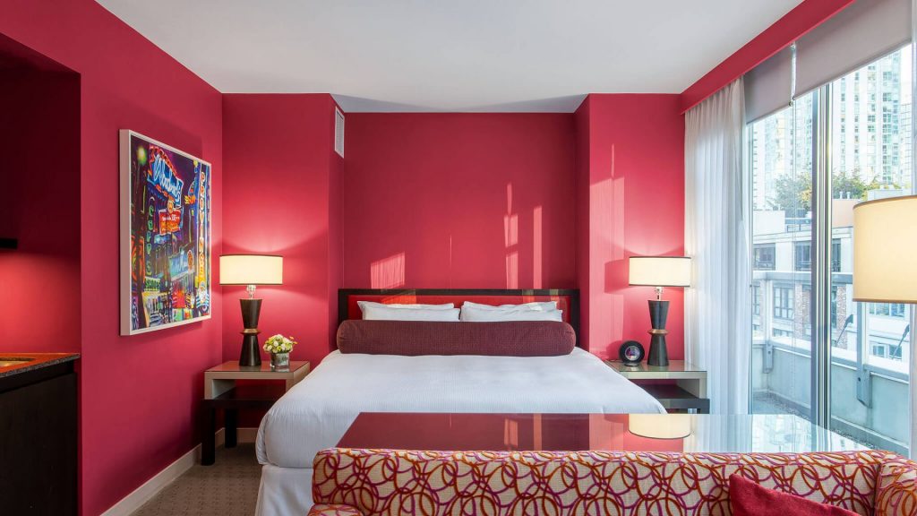 OPUS Vancouver's red room with a balcony and pop art on the wall
