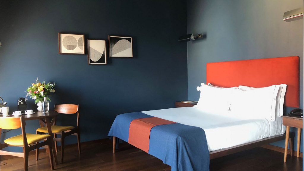 The Vintage Lisbon hotel's Superior Blue Room with blue walls and a red headboard