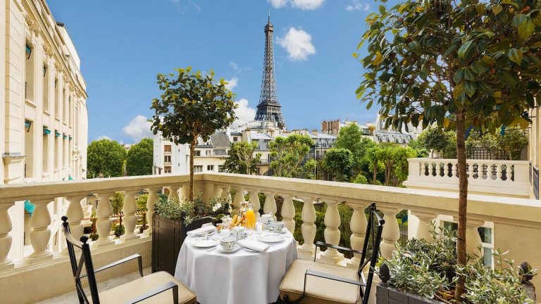 Breakfast on a table for two on a terrace at the Shangri-La Paris with a view of the Eiffel Tower
