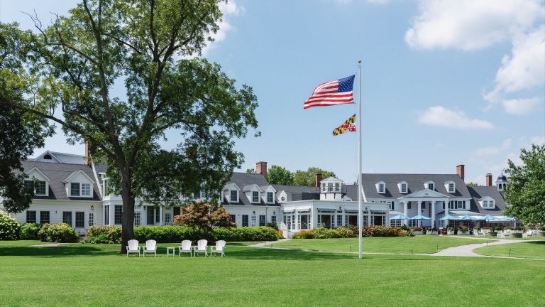Green lawn with an American flag in front of the Inn at Perry Cabin